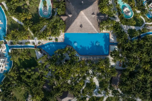 Aerial view of El Dorado Royale Riviera Maya showcasing tropical grounds, interconnected pools, palm-lined pathways, and accommodations at an adults-only all-inclusive resort in Mexico.
