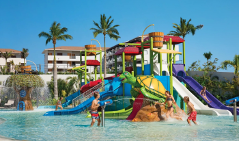 Kids playing at the turtle-themed water park with slides at Dreams Playa Mujeres Kids playing at the turtle-themed water park with slides at Dreams Playa Mujeres