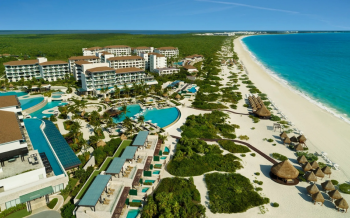 Aerial view of Dreams Playa Mujeres resort buildings, pools, and beach along the Riviera Maya coastline Aerial view of Dreams Playa Mujeres resort buildings, pools, and beach along the Riviera Maya coastline